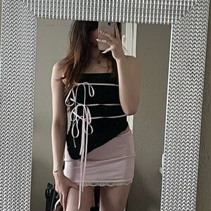 Asymmetrical black tube top with pink ribbons